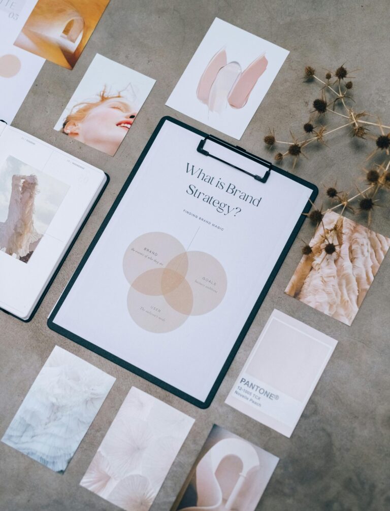 Aesthetic flat lay of branding and design documents on textured surface.